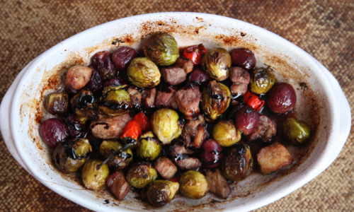 Coles de Bruselas asadas con uvas, vino tinto y balsámico.