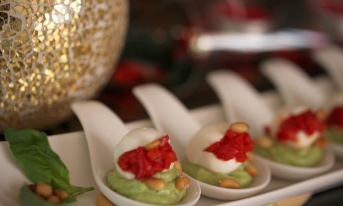 Perlas de mozzarella con pimientos de piquillo, aguacate, piñones y un toque de albahaca.