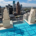 Una casa con piscina infinita y suelo de cristal sobre el cielo de Houston.